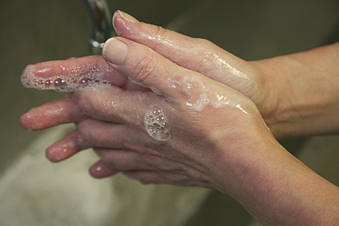 Photo showing hands being washed with soap and water